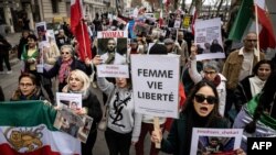 FILE - Protestors hold portraits of jailed Iranian rapper Toomaj Salehi (C) and Mohsen Shekari (Bottom-R), a protestor who was executed in Iran in December 2022, during a rally in Lyon, France, on January 8, 2023. 