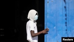 Seorang tahanan berdiri di dekat gerbang Lembaga Pemasyarakatan Nasional Haiti menyusul kerusuhan yang berujung pada aksi pembobolan penjara tersebut di Port-au-Prince, pada 3 Maret 2024. (Foto: Reuters/Ralph Tedy Erol)