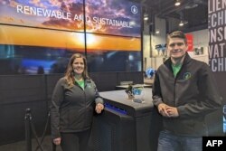 Salah satu pendiri Genesis Systems Shannon Stuckenberg (kiri) dan David Stuckenberg berpose dengan perangkat WaterCube yang mengekstraksi air dari udara selama Consumer Electronics Show (CES) di Las Vegas, Nevada, 12 Januari 2024. (Glenn CHAPMAN / AFP)