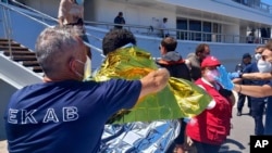 Survivors receive first aid after a rescue operation at the port in Kalamata town, about 240 kilometers (150 miles) southwest of Athens on June 14, 2023. 