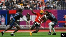 FILE - AFC wide receiver Tyreek Hill (10) of the Miami Dolphins carries the ball against NFC cornerback Tariq Woolen (27) of the Seattle Seahawks and outside linebacker Za'Darius Smith (55) of the Minnesota Vikings at the NFL Pro Bowl, Feb. 5, 2023, in Las Vegas. 