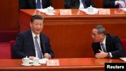 រូបឯកសារ៖ ប្រធានាធិបតីចិនលោក Xi Jinping និងនាយករដ្ឋមន្ត្រីចិន​លោក Li Qiang ជជែកគ្នា​ក្នុងអំឡុងសមាជ​ប្រចាំឆ្នាំ នៅទីក្រុងប៉េកាំង ប្រទេសចិន កាលពីថ្ងៃទី៤ ខែមីនា ឆ្នាំ២០២៤។ 