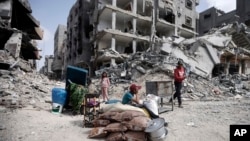 Palestinians sit by their belonginsg after visiting their houses destroyed in the Israeli offensive on Khan Younis, Gaza Strip, March 6, 2024. 