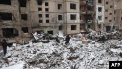 Police and residents inspect damage outside a destroyed building after a Russian missile attack in Kyiv, Jan. 3, 2024. Meanwhile, Ukraine said on Thursday that its air force struck two Russian military targets in occupied Crimea, including a command post near Sevastopol.