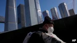 资料照片: 北京商务区一名扛着行李的打工人 (2023年3月15日)