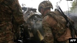 FILE - Ukrainian paratroopers fire an L119 howitzer towards Russian positions at a front line in the Luhansk region on April 20, 2023. 