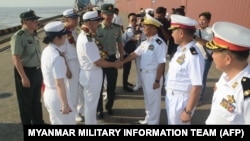 缅甸军事信息小组照片显示，缅甸海军高官（右）欢迎中国海军官兵抵达仰光迪洛瓦港。（2023年11月27日）