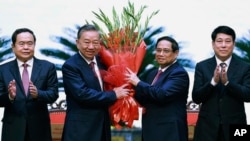 Vietnamese Prime Minister Pham Minh Chinh, right, congratulates Vietnamese President To Lam with flowers as he was confirmed the new Community Party Chief, the country's most powerful role, on Aug. 3, 2024, Hanoi, Vietnam. 
