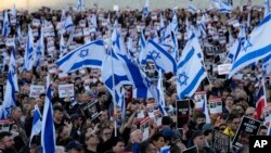 FILE - People carry Israeli flags and pictures of people believed taken hostage and held in Gaza, during a protest in Trafalgar Square, London, Oct. 22, 2023.