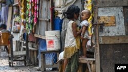 FILE - Rohingya refugee children stand along a street at a refugee camp on the World Refugee Day, in New Delhi on June 20, 2023. 