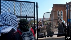 Police replace a piece of fence knocked down by protesters surrounding the United Center at the Democratic National Convention after a march, Aug. 19, 2024, in Chicago.