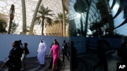 People walk through the COP28 UN Climate Summit near Al Wasl Dome at Expo City, Dec. 3, 2023, in Dubai, United Arab Emirates.