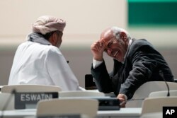A delegate from Bolivia, right, laughs ahead of a stocktaking plenary session at the COP28 U.N. Climate Summit in Dubai, United Arab Emirates, Dec. 9, 2023.