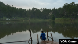 បុរស​ម្នាក់​អង្គុយ​ក្បែរ​បឹង​ក្នុង​ឧទ្យានជាតិ​គិរីរម្យ កាលពី​ខែកក្កដា ឆ្នាំ​២០២០។ (ទុំ ម្លិះ/វីអូអេ)