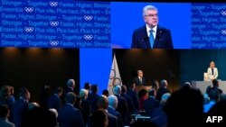 International Olympic Committee (IOC) President Thomas Bach (C, right) addresses delegates on the first day of the 141st IOC Session in Mumbai, India, Oct. 15, 2023.