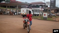 Dereva wa pikipiki akisukuma pikipiki yake kutoka kwenye kituo cha mafuta ambacho kiliishiwa mafuta huko Kampala Uganda Januari 18, 2022. Picha na Badru KATUMBA/AFP.