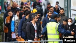 독일에서 망명을 신청하려는 사람들이 베를린 소재 접수센터에서 줄을 서서 기다리고 있다. (자료사진)