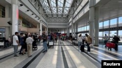 People stand near their luggage at the Beirut-Rafic Al Hariri International Airport, in Beirut, Lebanon, Aug. 4, 2024.