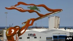 A sculpted figure representing a man waving a Lebanese flag stands along the road overlooking the port of Beirut on Aug. 4, 2024, as Lebanon marks four years since a catastrophic explosion there that killed more than 220 people.
