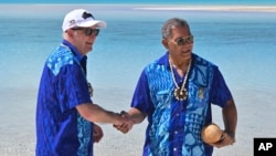 Australia's Prime Minister Anthony Albanese, left, and Tuvalu's Prime Minister Kausea shake hands on One Foot Island after attending the Leaders' Retreat during the Pacific Islands Forum in Aitutaki, Cook Islands, Nov. 9, 2023.