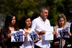 Sejumlah wartawan Lebanon memegang foto mendiang jurnalis video Reuters, Issam Abdallah, dalam demo di depan markas PBB di Beirut, Lebanon, 15 Oktober 2023. Issam tewas oleh oleh tembakan roket Israel saat meliput bentrokan di perbatasan Lebanon. (Foto: Hassan Ammar/AP Photo)