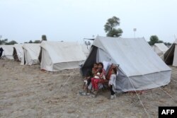 Anak-anak terlihat di depan tenda mereka di kamp untuk masyarakat korban banjir dekat Pakpattan, Pakistan, 26 Agustus 2023. (Shahid Saeed Mirza / AFP)