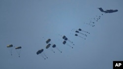 An aircraft airdrops humanitarian aid over Gaza the northern Gaza Strip, as seen from southern Israel, March 8, 2024.