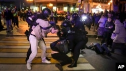FILE - Riot police detain two young men at a demonstration in Moscow, Russia, on Sept. 21, 2022. 