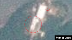 24일 동창리 새 발사장을 촬영한 위성사진. 이동식 조립건물(화살표) 남쪽 지대에 큰 하얀색 물체가 보인다. 사진=Planet Labs