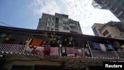 People look out from a common balcony of a Chawl, home to hundreds of families, during a 21-day nationwide lockdown to slow the spreading of coronavirus disease (COVID-19), in Mumbai, India, March 31, 2020.