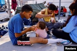 미국에서 추방된 베네수엘라 출신 불법 이주자들이 16일 멕시코 역내 국경 교량 인근에서 식사하고 있다.