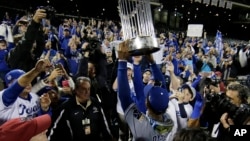 Kansas City Royals' Jarrod Dyson holds the World Series trophy after Game 5 of the Major League Baseball World Series against the New York Mets Monday, Nov. 2, 2015.