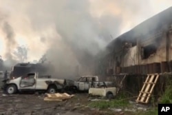 In this image from video, smoke envelopes a building as emergency services attend an early-morning fire in Congo's capital Kinshasa, Dec. 13, 2018, which is reported to have destroyed thousands of voting machines just 10 days before the upcoming presidential election.