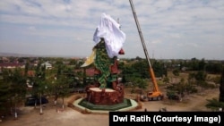 Workers cover the statue of the Chinese warrior god known variously as Kwan Sing Tee Koen, Kwan Kong, Kuan-Ti or Guan-Yu, in Tuban, East Java.