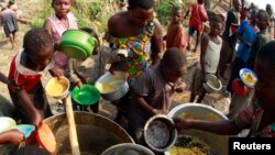 Congolese refugees, displaced by fighting between the Congo army and rebel group Allied Democratic Forces (ADF) last week, gather to collect food at the Bukanga transit camp in Bundibugyo town camp, 376 km (238 miles) southwest of Kampala, July 17, 2013.