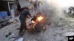 A man tries to put out a fire after a car bomb exploded in Tal Abyad, Syria, Friday, Nov. 2, 2019. 
