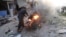 A man tries to put out a fire after a car bomb exploded in Tal Abyad, Syria, Friday, Nov. 2, 2019. 