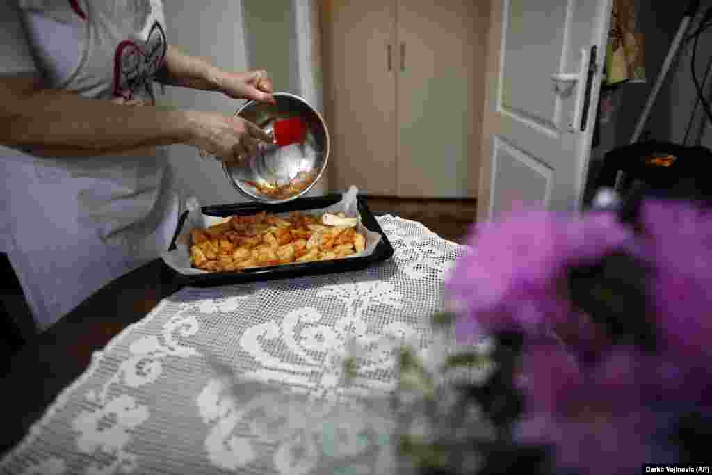 Jelena Petrovic prepares food in her home and puts it in the oven.