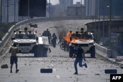 Supporters of Venezuelan opposition leader and self-proclaimed acting president Juan Guaido clash with forces loyal to President Nicolas Maduro after members of the Bolivarian National Guard joined Guaido's campaign to oust him, in front of La Carlota military base in Caracas, April 30, 2019.