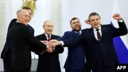 From left to right, the Moscow-appointed heads of Kherson region Vladimir Saldo and Zaporizhzhia region Yevgeny Balitsky, Russian President Vladimir Putin, Donetsk separatist leader Denis Pushilin and Lugansk separatist leader Leonid Pasechnik join hands 