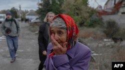 Seorang perempuan tampak menangis di jalan setelah sebuah serangan roket menghantam wilayah Mykolaiv, Ukraina, pada 23 Oktober 2022. (Foto: AFP/Bulent Kilic)