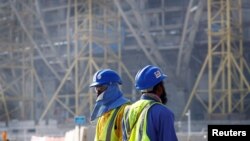FILE - Workers are seen at the construction site of the Lusail stadium being built for the 2022 FIFA soccer World Cup, in Doha, Qatar, Dec. 20, 2019.