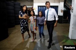 FILE - Rishi Sunak, his wife Akshata Murthy and their daughters Anoushka and Krishna attend a Conservative Party leadership campaign event in Grantham, Britain, July 23, 2022.