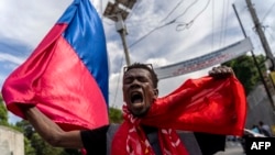 FILE - Amid a cholera and security crisis in Haiti, people demonstrate in Port-au-Prince against Haitian Prime Minister Ariel Henry and the United Nations, Oct. 21, 2022.