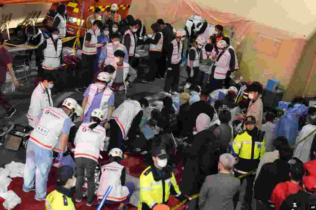 Rescue workers treat injured people on the street near the scene in Seoul, South Korea, Oct. 30, 2022.