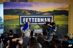 Pennsylvania Lt. Gov. John Fetterman, Democratic candidate for U.S. Senate, right, greets supporters with Sen. Amy Klobuchar, D-Minn., at Stolen Sun Craft Brewing Company in Exton, Pa., Oct. 22, 2022.