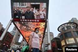 资料照：北京街头的大屏幕电视报道中国领导人习近平在新疆参观视察。（2022年7月15日）