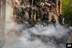 Firefighters try to extinguish a fire after a drone fired at buildings in Kyiv, Ukraine, Monday, Oct. 17, 2022. (AP Photo/Efrem Lukatsky)