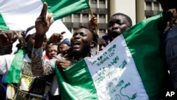 FILE - In this Oct. 20, 2020 photo, people hold banners as they demonstrate on the street to protest against police brutality, in Lagos, Nigeria.
