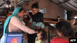 A health worker administers polio vaccine drops to a child during a vaccination campaign in Lahore, Pakistan, October 24, 2022. 